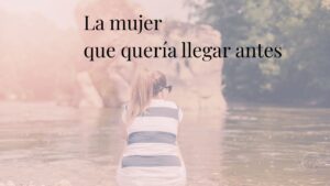 Mujer sentada de espaldas junto a un río, observando el agua en un momento de calma y presencia.
